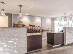 a lobby with a reception desk with a painting on the wall at La Quinta by Wyndham Columbia / Fort Meade in Jessup