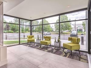 - un salon avec de grandes fenêtres, une table et des chaises dans l'établissement La Quinta by Wyndham Salem NH, à Salem