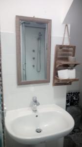uma casa de banho com um lavatório branco e um espelho. em casa nonna Emma em Iglesias