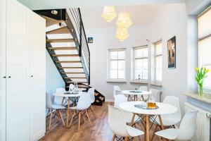 Pokój z dwoma stołami i krzesłami oraz schodami w obiekcie Apartment Zamojska 8 - Apartamenty GKM Lublin w mieście Lublin