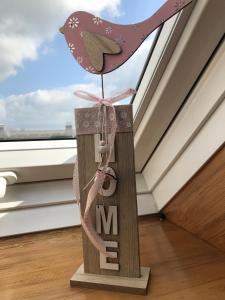 a wooden bird on a wooden stand with the letter m at Ferienwohnung Pamme in Hanerau-Hademarschen