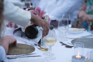 een persoon die een glas wijn op een tafel giet bij Reef Villa in Wadduwa