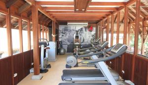 un gimnasio con una fila de cintas de correr y máquinas en Pavilion Samui Villas and Resort - SHA Extra Plus en Lamai Beach