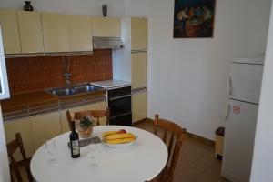 a kitchen with a table with a plate of fruit on it at Tania Apartment in Prizba