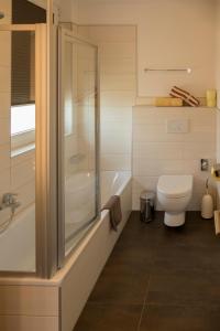 uma casa de banho com um chuveiro, um WC e uma banheira em Hotel Sonnengarten em Sommerhausen