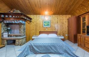 a bedroom with a bed and a stone fireplace at Cottage Nilda I in Poreč