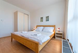 ein Schlafzimmer mit einem großen Bett mit weißer Bettwäsche in der Unterkunft Apartmán U Lázní D23 in Třeboň