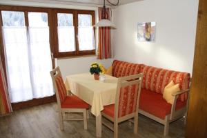 een woonkamer met een tafel en een bank bij Gästehaus Auerstüble in Balderschwang
