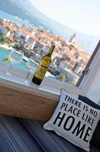 - une bouteille de vin assise sur un rebord de fenêtre avec un oreiller dans l'établissement Apartment Marina, à Korčula