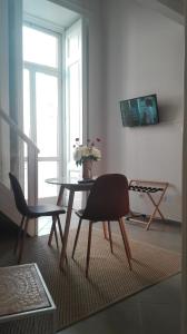 stół i krzesła w salonie z wazonem kwiatów w obiekcie Piano Nobile w mieście Napoli