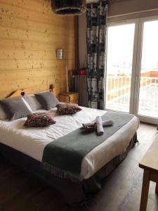 a bedroom with a large bed in a room with windows at Le Ptit Hotel du Lac in Gérardmer