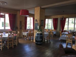熱拉梅的住宿－Le Ptit Hotel du Lac，用餐室设有桌椅和窗户。