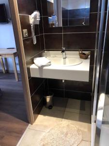 a bathroom with a sink and a phone on the wall at Le Ptit Hotel du Lac in Gérardmer