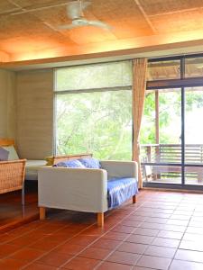 ein Wohnzimmer mit Couch und großem Fenster in der Unterkunft Nantou Puli Sunrise Villa Homestay B&B in Puli