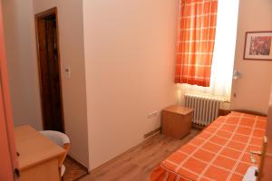 Habitación pequeña con cama, mesa y ventana en Hotel Dulovic en Mojkovac
