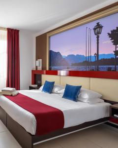 una camera da letto con un grande letto con una grande finestra di Kairos Garda Hotel a Castelnuovo del Garda