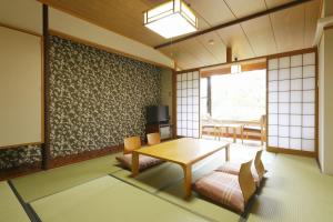 a japanese room with a table and a tv at Kyukamura Noto-Chirihama in Hakui +14 photos