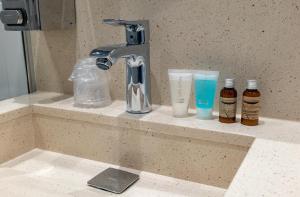 
a bathroom sink with a soap dispenser next to it at Copenhagen Go Hotel in Copenhagen

