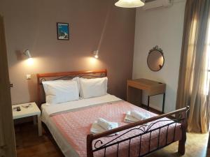 1 dormitorio con cama y espejo en Kastro Studios, en Skopelos Town