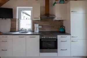 a kitchen with white cabinets and a stove and a window at Apartment Eva in Wimbach