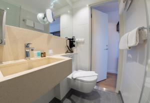 
a bathroom with a toilet, sink, and shower at Copenhagen Go Hotel in Copenhagen
