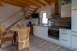 eine Küche mit weißen Schränken, einem Tisch und Stühlen in der Unterkunft Apartment Eva in Wimbach