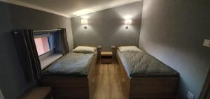 a small room with two beds and a window at Budziechów Noclegi in Lubsko