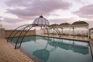 a swimming pool with a gazebo next to the water at Ramada Plaza By Wyndham, Chandigarh Zirakpur in Chandīgarh