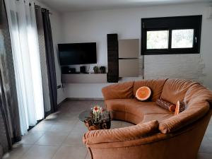 a living room with a brown couch and a tv at Villa Chiara in Limenaria