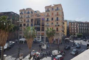 eine Stadtstraße mit Autos, Palmen und Gebäuden in der Unterkunft B&B Toledo one in Neapel