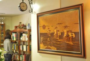 a woman standing in a library with a painting on the wall at Hotel Tres Carabelas in Baiona