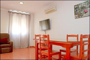 - une salle à manger avec une table et des chaises en bois dans l'établissement Dalí al Mar, à Conil de la Frontera