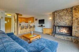 a living room with a blue couch and a fireplace at 1 Bath Studio Apartment in Snowmass Village in Snowmass Village