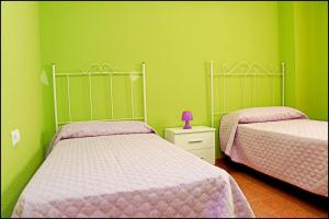 - 2 lits dans une chambre aux murs verts dans l'établissement Dalí al Mar, à Conil de la Frontera