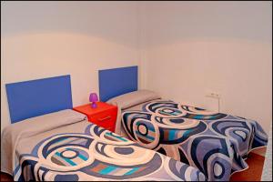 - une chambre avec 2 lits et une table rouge dans l'établissement Dalí al Mar, à Conil de la Frontera