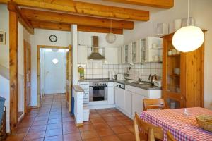 a kitchen with white appliances and a table with a table cloth at Wohnung 2 Landhaus II in Pieverstorf
