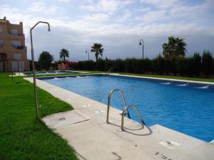 ein großer Pool mit zwei Metallschienen im Gras in der Unterkunft Playa de Los Lances in Tarifa