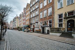 a cobblestone street in a city with tall buildings at Elite Apartments Piwna Premium in Gdańsk