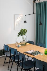 a dining room table with chairs and a potted plant at Wolken en Zout in Bredene