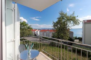 balcón con mesa y vistas al océano en Apartments Amabilis, en Selce