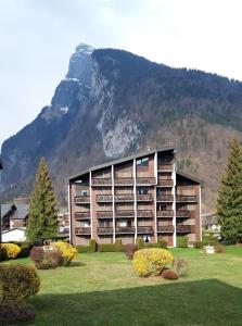 a large building with a mountain in the background at Résidence "Rado" in Samoëns