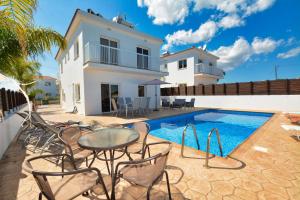 a villa with a swimming pool and a house at Nissi Villa Gintare in Ayia Napa