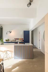 a kitchen with white walls and blue cabinets at Wolken en Zout in Bredene