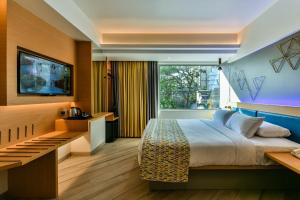 a hotel room with a bed and a television at Indie Stays in Mumbai
