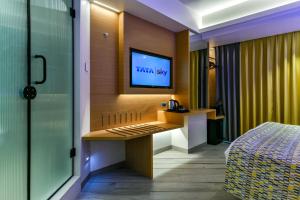 ein Hotelzimmer mit einem TV an der Wand in der Unterkunft Indie Stays in Mumbai