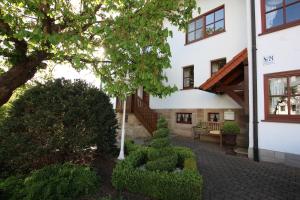 a building with a bench and trees in front of it at Schicke Ferienwohnung für 2 in Niederkalbach