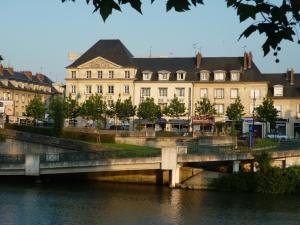 un pont sur une rivière devant un bâtiment dans l'établissement Cit'Hotel De Harlay, à Compiègne