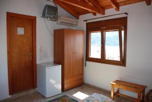 a room with a refrigerator and a window and a television at Hotel Bonis in Samos