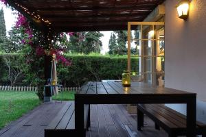 - une table en bois sur une terrasse avec un banc dans l'établissement Margarida Charming House in Cascais, à Cascais
