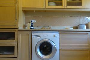 une cuisine avec une machine à laver dans une cuisine dans l'établissement Margarida Charming House in Cascais, à Cascais